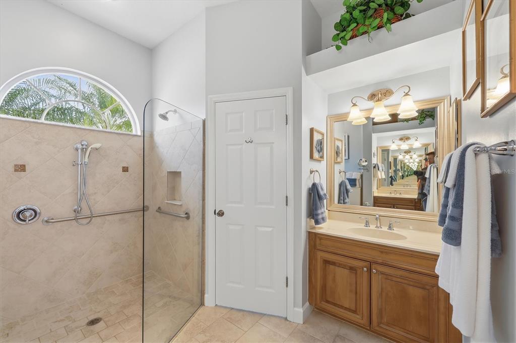 3606 Pennyroyal Road Port Charlotte, FL 33953 - Photo 39 of 96 a bathroom with a granite countertop a sink a mirror a vanity and a shower