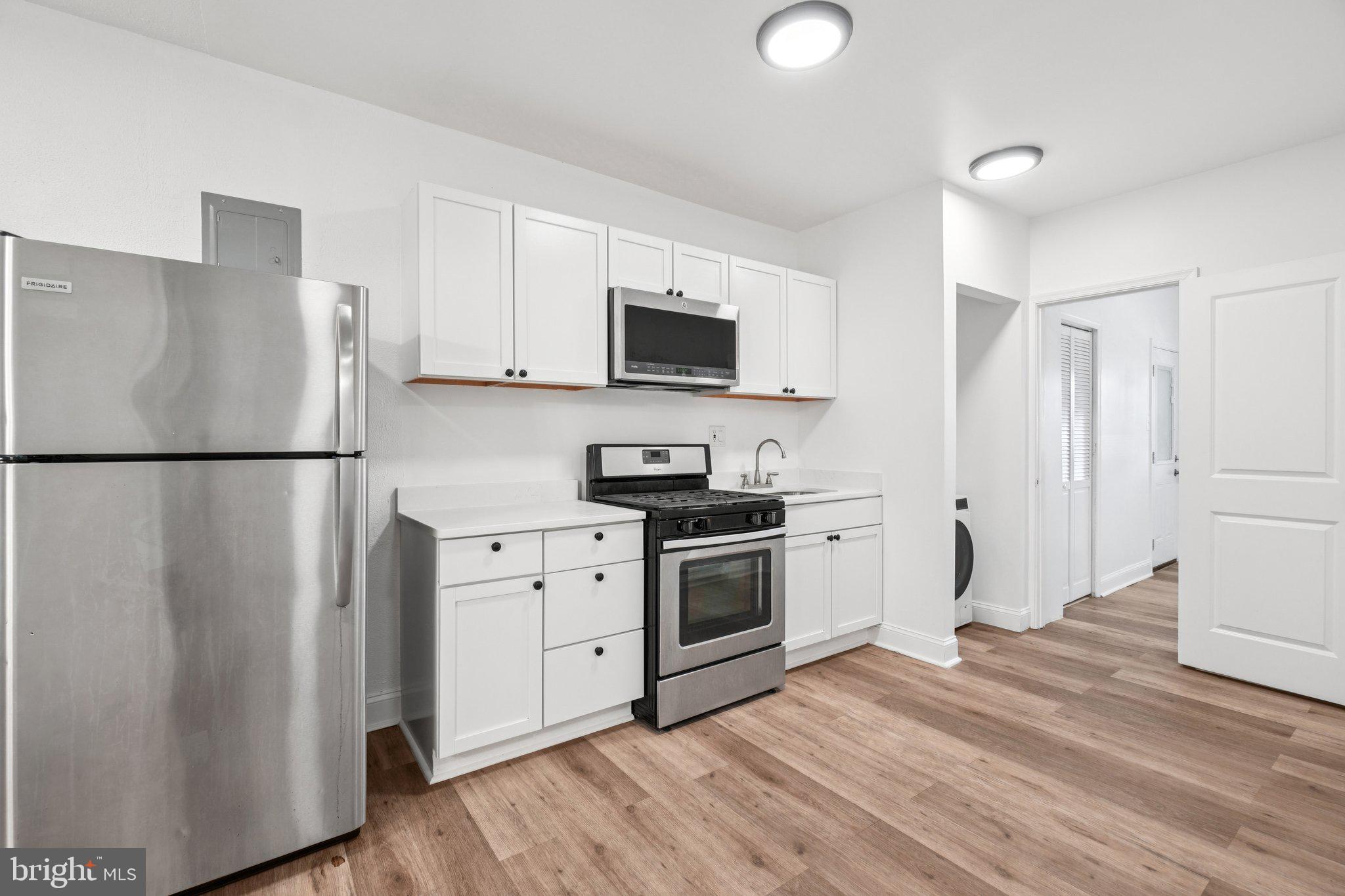 221 20th Street Northeast Washington, DC 20002 - Photo 2 of 26 a kitchen with a refrigerator stove and white cabinets