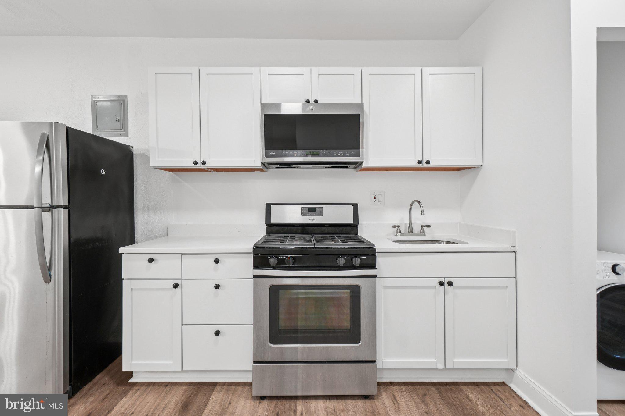 221 20th Street Northeast Washington, DC 20002 - Photo 3 of 26 a kitchen with stainless steel appliances granite countertop white cabinets and a stove