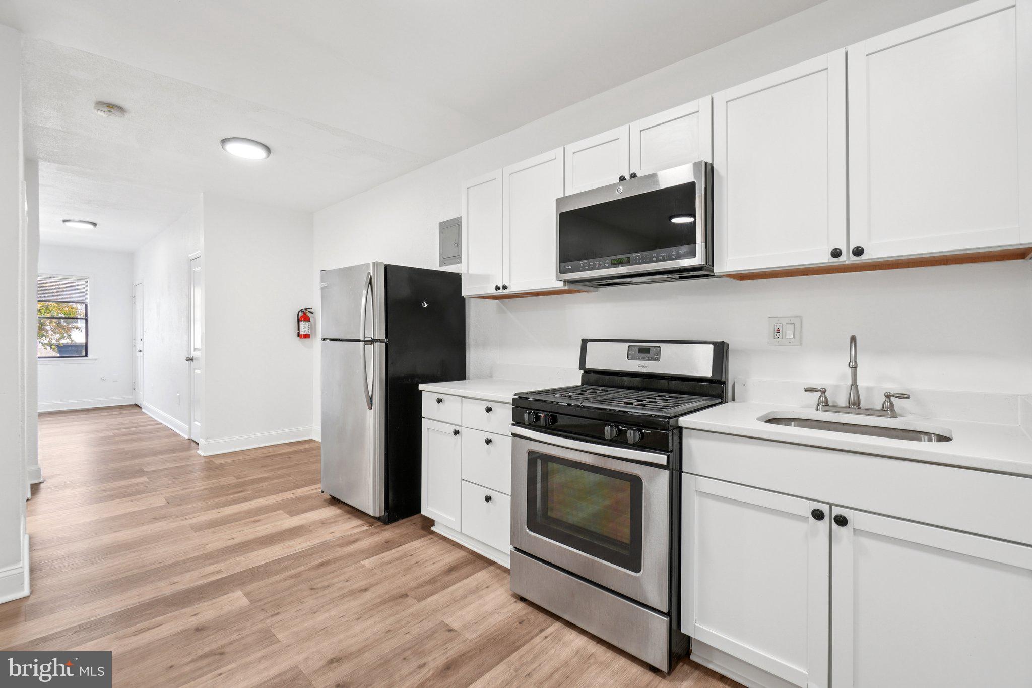 221 20th Street Northeast Washington, DC 20002 - Photo 4 of 26 a kitchen with stainless steel appliances granite countertop a stove a refrigerator and a microwave