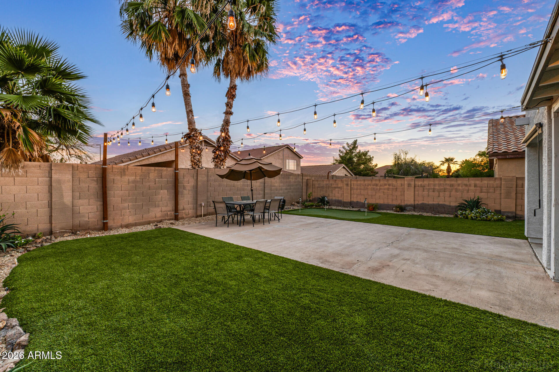 3033 East Santa Rosa Drive Gilbert, AZ 85234 - Photo 21 of 24 a view of a backyard with table and chairs potted plants and a palm tree