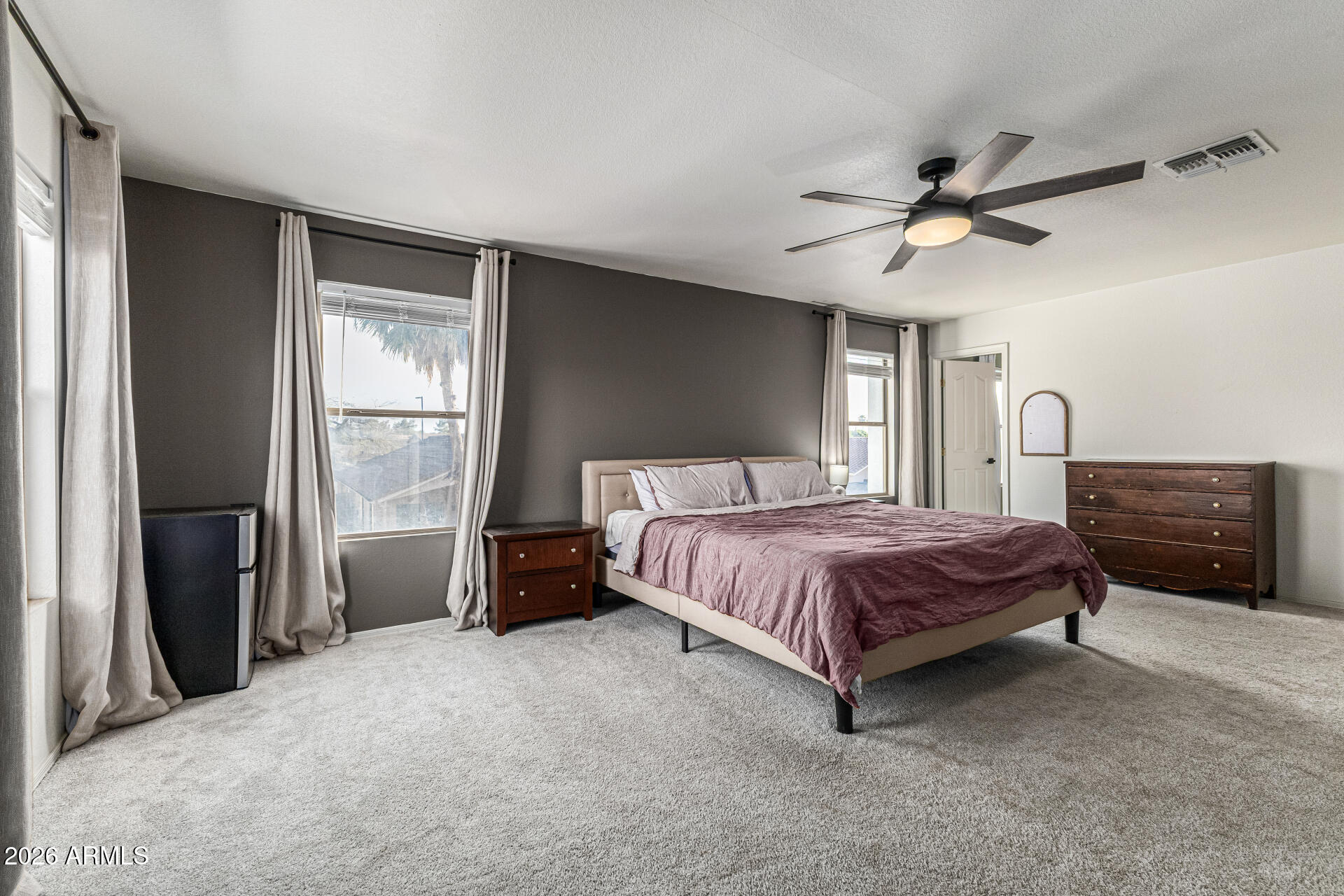 3033 East Santa Rosa Drive Gilbert, AZ 85234 - Photo 3 of 24 a spacious bedroom with a bed a dresser and a chandelier