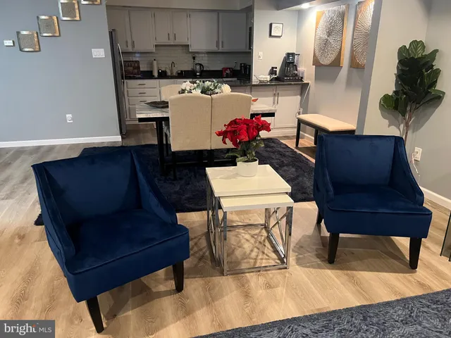 a living room with furniture and a dining table with kitchen view