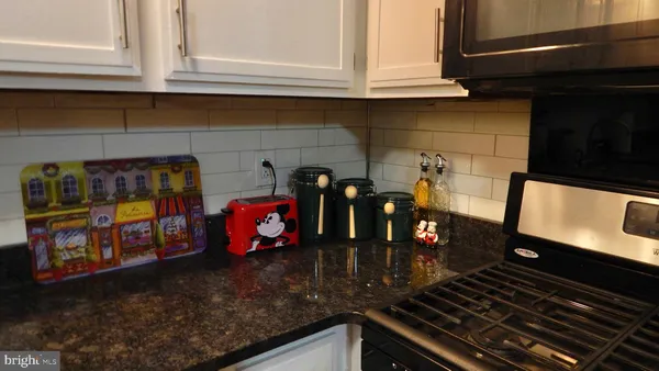 a kitchen with an oven a stove and a sink with granite countertops