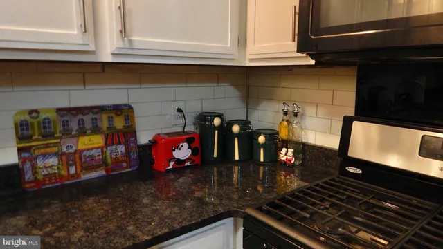 a kitchen with an oven a stove and a sink with granite countertops
