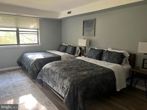 a bedroom with two beds and a window