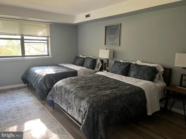 a bedroom with two beds and a window