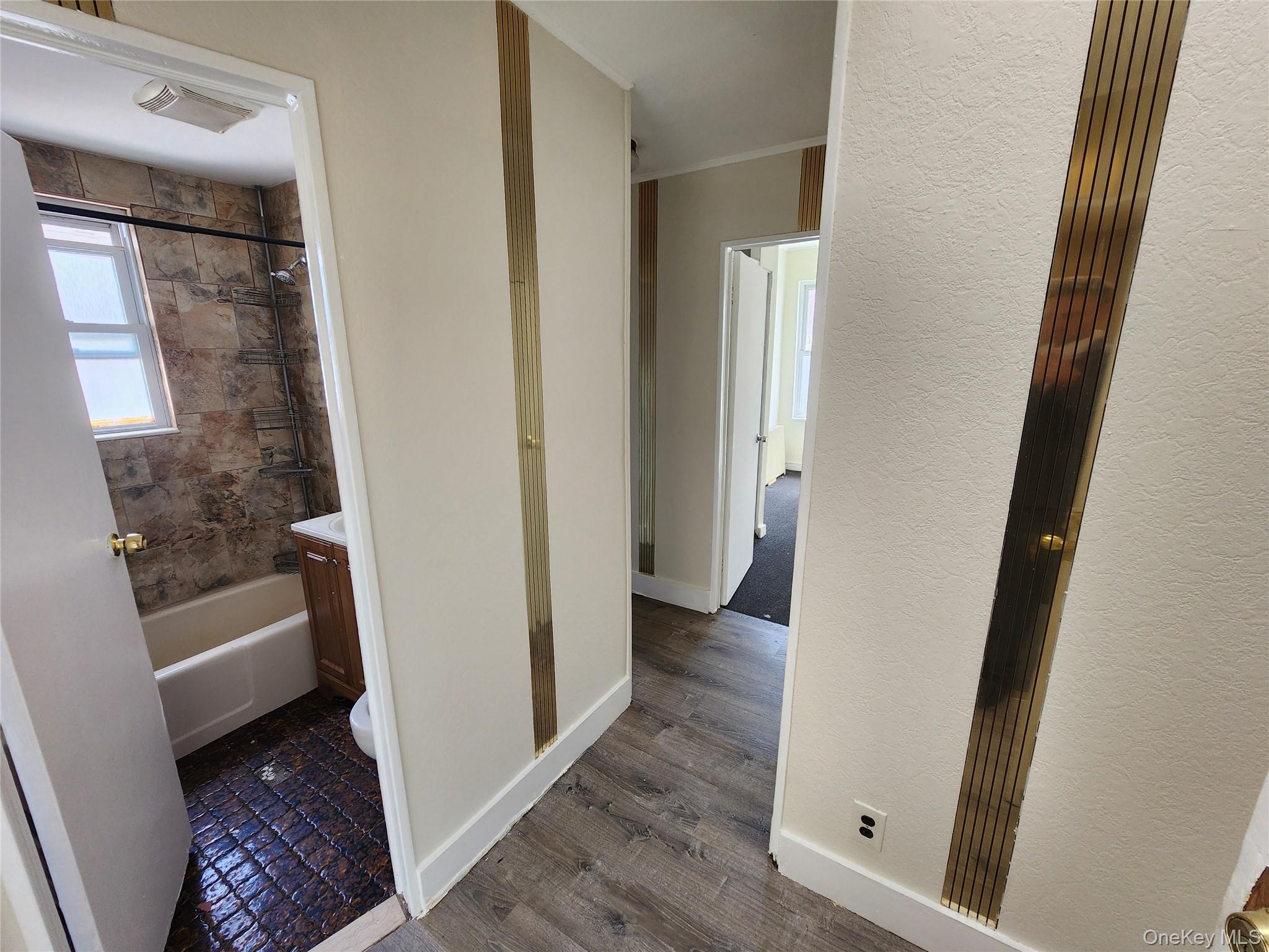 59-12 58th Road Queens, NY 11378 - Photo 12 of 21 a view of a hallway with wooden floor and furniture