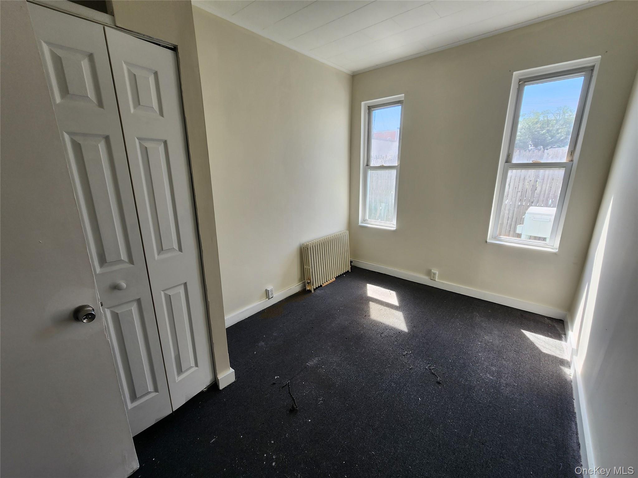 59-12 58th Road Queens, NY 11378 - Photo 14 of 21 an empty room with windows