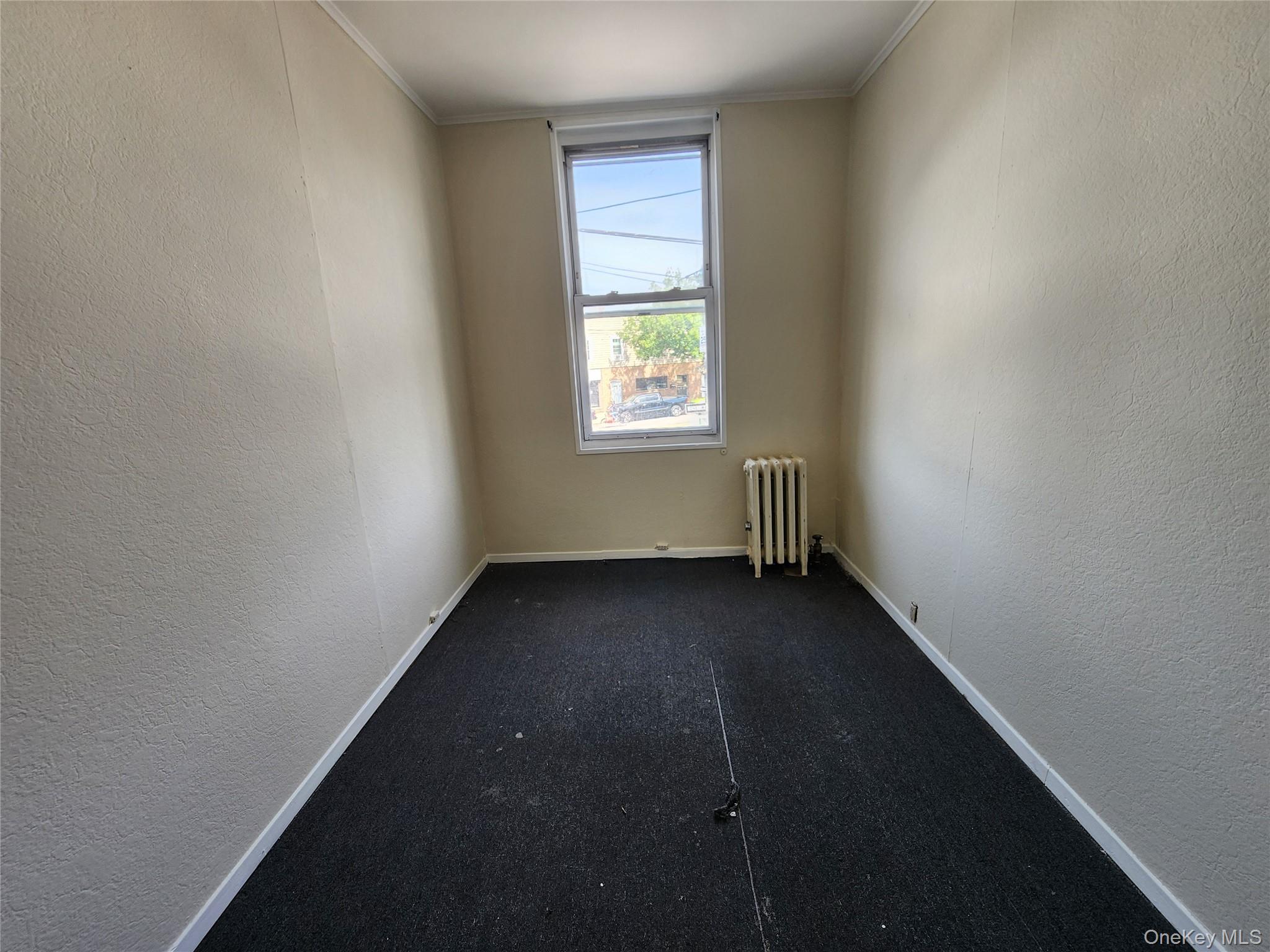 59-12 58th Road Queens, NY 11378 - Photo 17 of 21 an empty room with a window