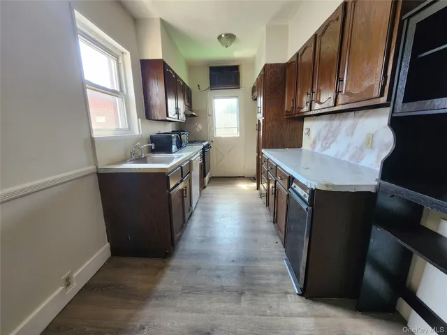 a kitchen with stainless steel appliances granite countertop a stove top oven a sink dishwasher and a refrigerator with wooden cabinets