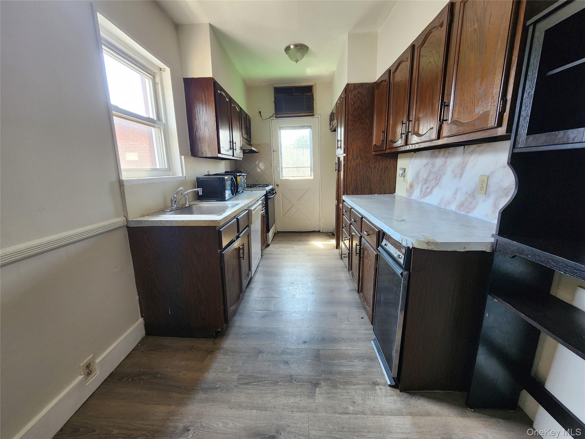 59-12 58th Road Queens, NY 11378 - Photo 6 of 21 a kitchen with stainless steel appliances granite countertop a stove top oven a sink dishwasher and a refrigerator with wooden cabinets