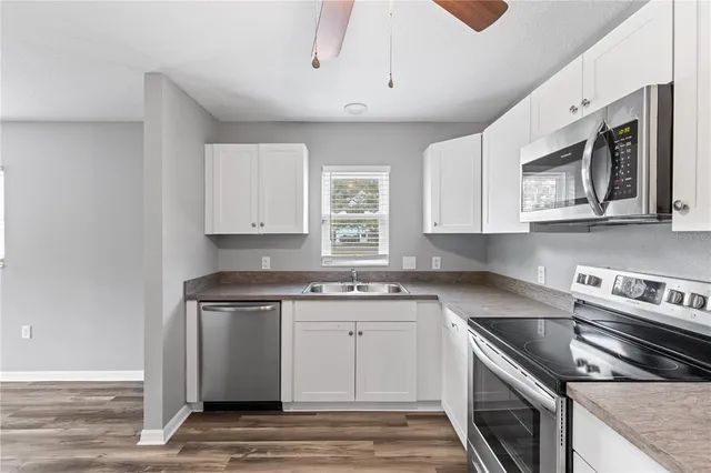 a kitchen with stainless steel appliances granite countertop a stove a sink and a microwave