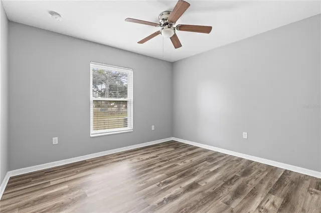 an empty room with fan and windows