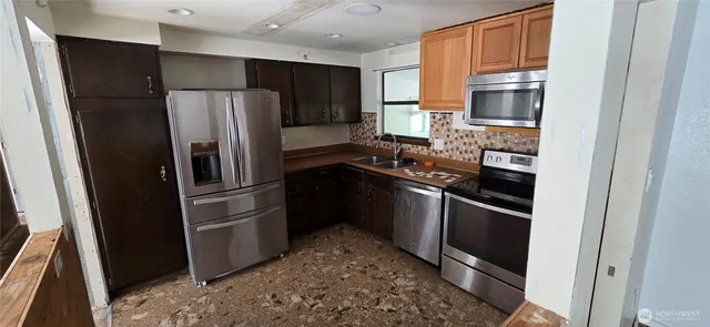 a kitchen with a refrigerator stove and sink