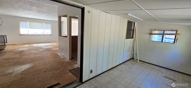 an empty room with windows and closet