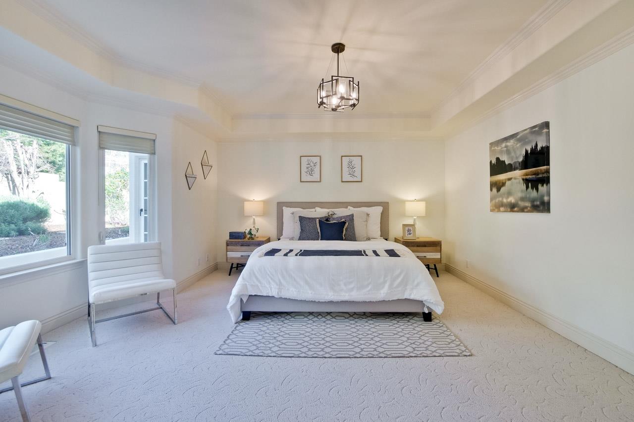 10935 Miramonte Road Cupertino, CA 95014 - Photo 39 of 71 a spacious bedroom with a bed and a chandelier