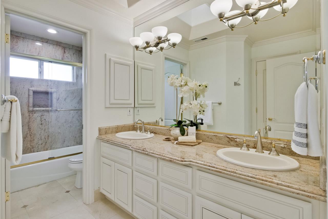 10935 Miramonte Road Cupertino, CA 95014 - Photo 51 of 71 a bathroom with a granite countertop sink a large mirror and a shower