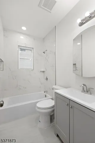 a bathroom with a sink a toilet and a large mirror