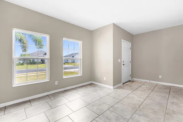 a view of an empty room with window and cabinet