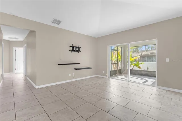 a view of an empty room with glass door and a window