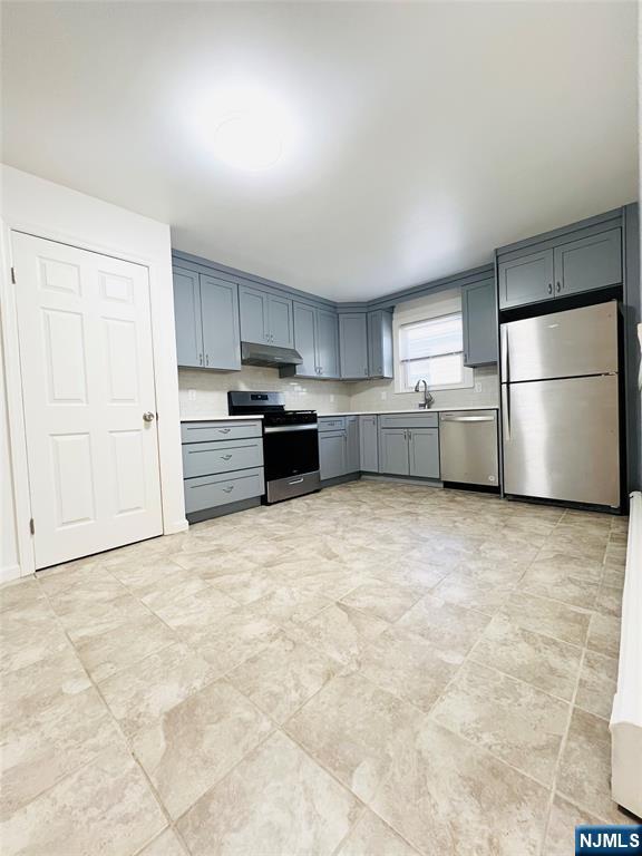 76 Front Street, Unit 2 North Arlington, NJ 07031 - Photo 2 of 13 a kitchen with granite countertop a refrigerator and a stove top oven