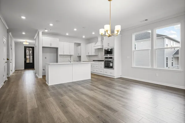 a view of a kitchen with granite countertop stainless steel appliances and wooden floor