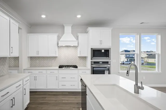 a kitchen with granite countertop a sink stainless steel appliances and cabinets