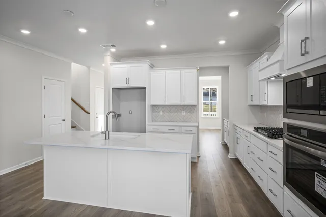 a kitchen with kitchen island granite countertop a sink cabinets and stainless steel appliances