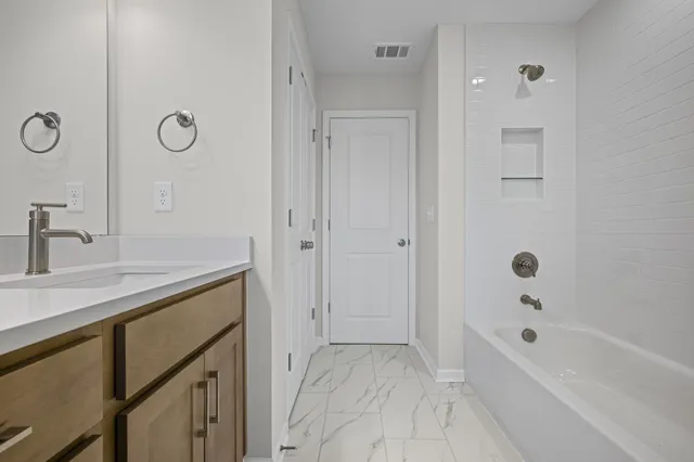 a bathroom with a tub sink and mirror