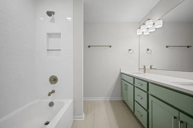 a bathroom with a tub sink shower and mirror