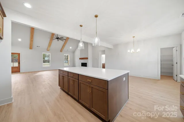 a view of a kitchen island a sink wooden floor and a living room