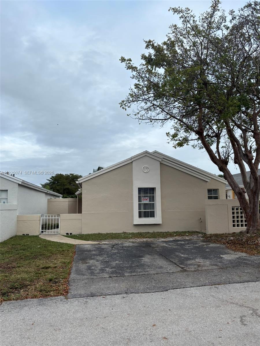 7331 Southwest 149th Court Miami, FL 33193 - Photo 24 of 25 a view of a white house with a yard and large tree