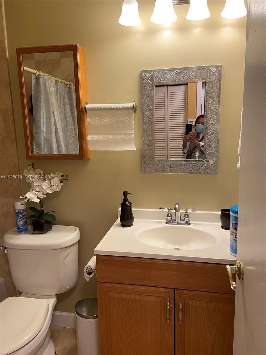 7331 Southwest 149th Court Miami, FL 33193 - Photo 6 of 10 a bathroom with a toilet a sink and mirror