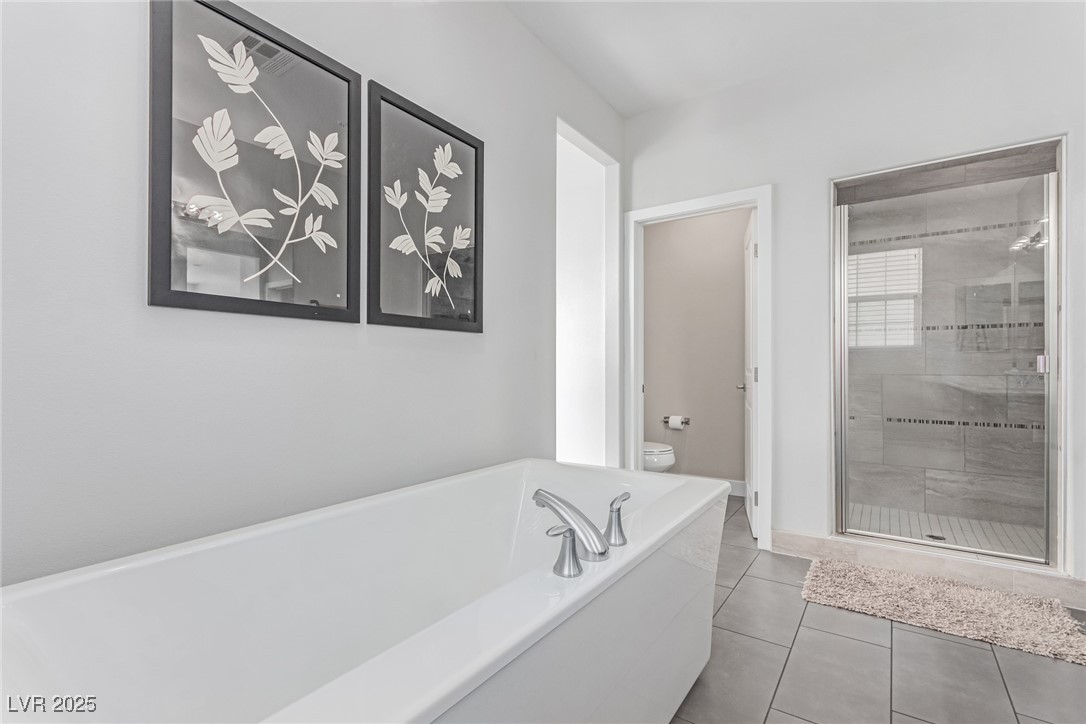 3165 Via Como Henderson, NV 89044 - Photo 13 of 42 Full bath featuring toilet, a shower stall, a tub to relax in, and tile patterned floors