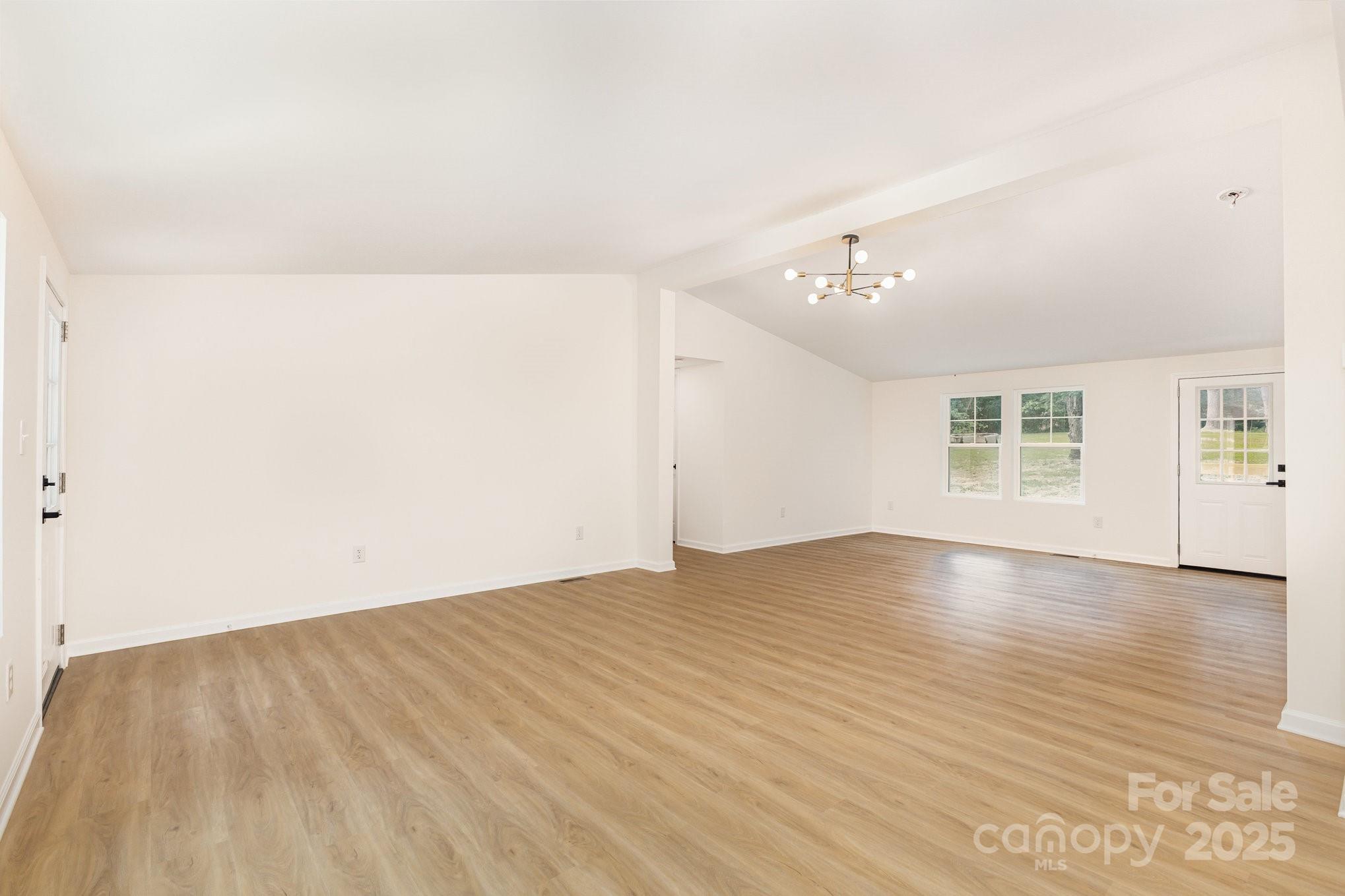 12180 A Coyle Road Stanfield, NC 28163 - Photo 3 of 16 an empty room with wooden floor and windows