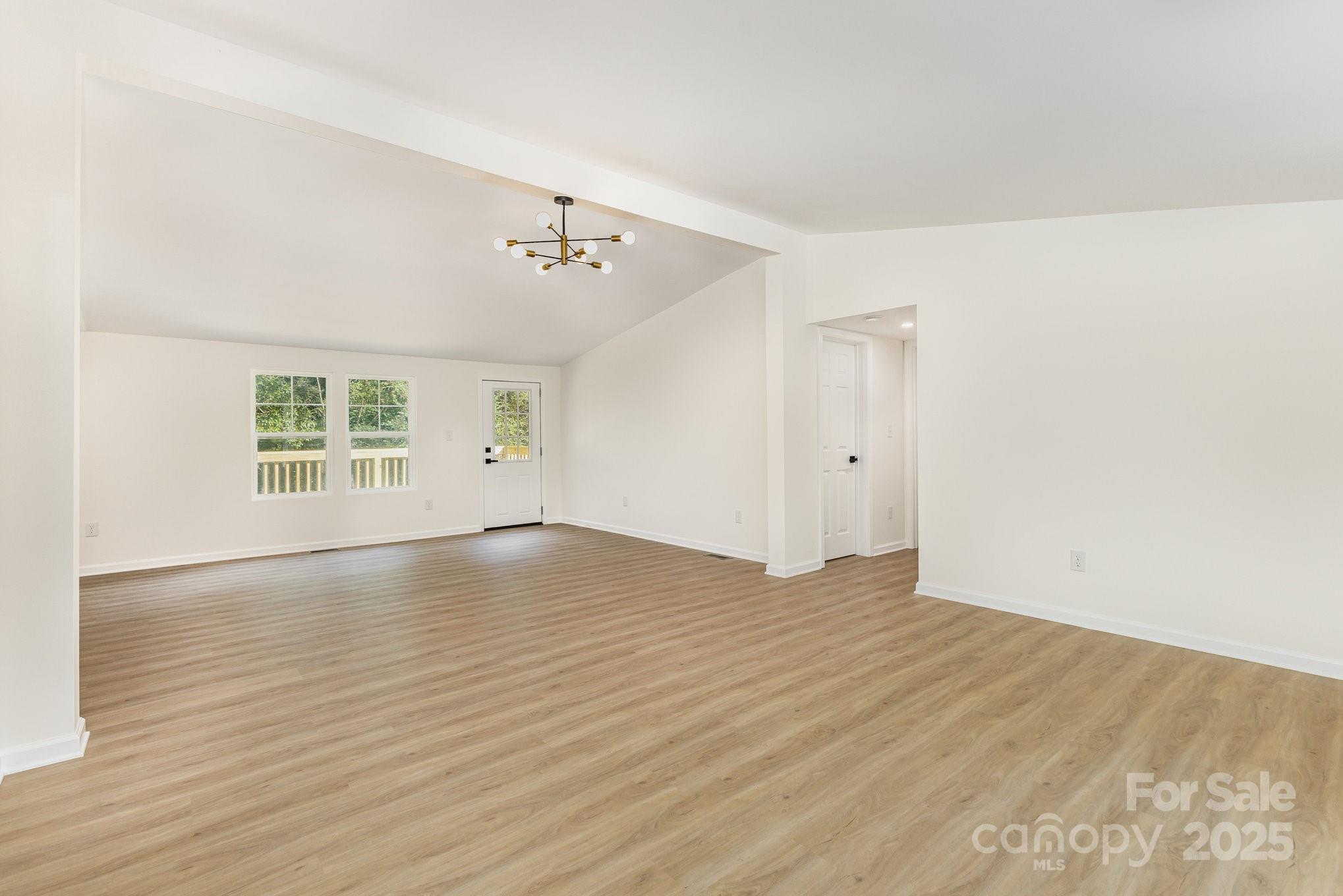 12180 A Coyle Road Stanfield, NC 28163 - Photo 4 of 16 a view of an empty room with wooden floor and a window