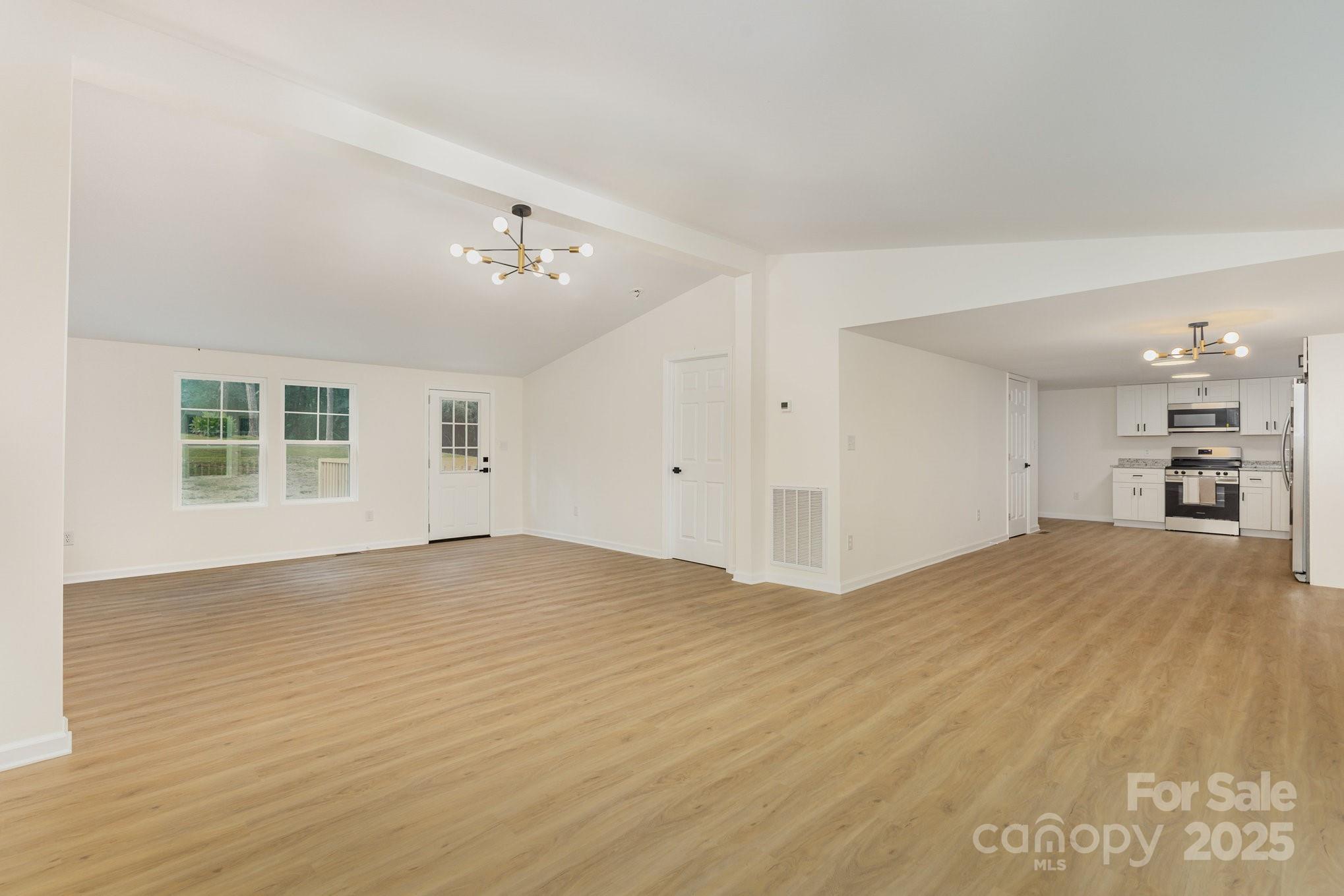 12180 A Coyle Road Stanfield, NC 28163 - Photo 5 of 16 a view of empty room with wooden floor and windows