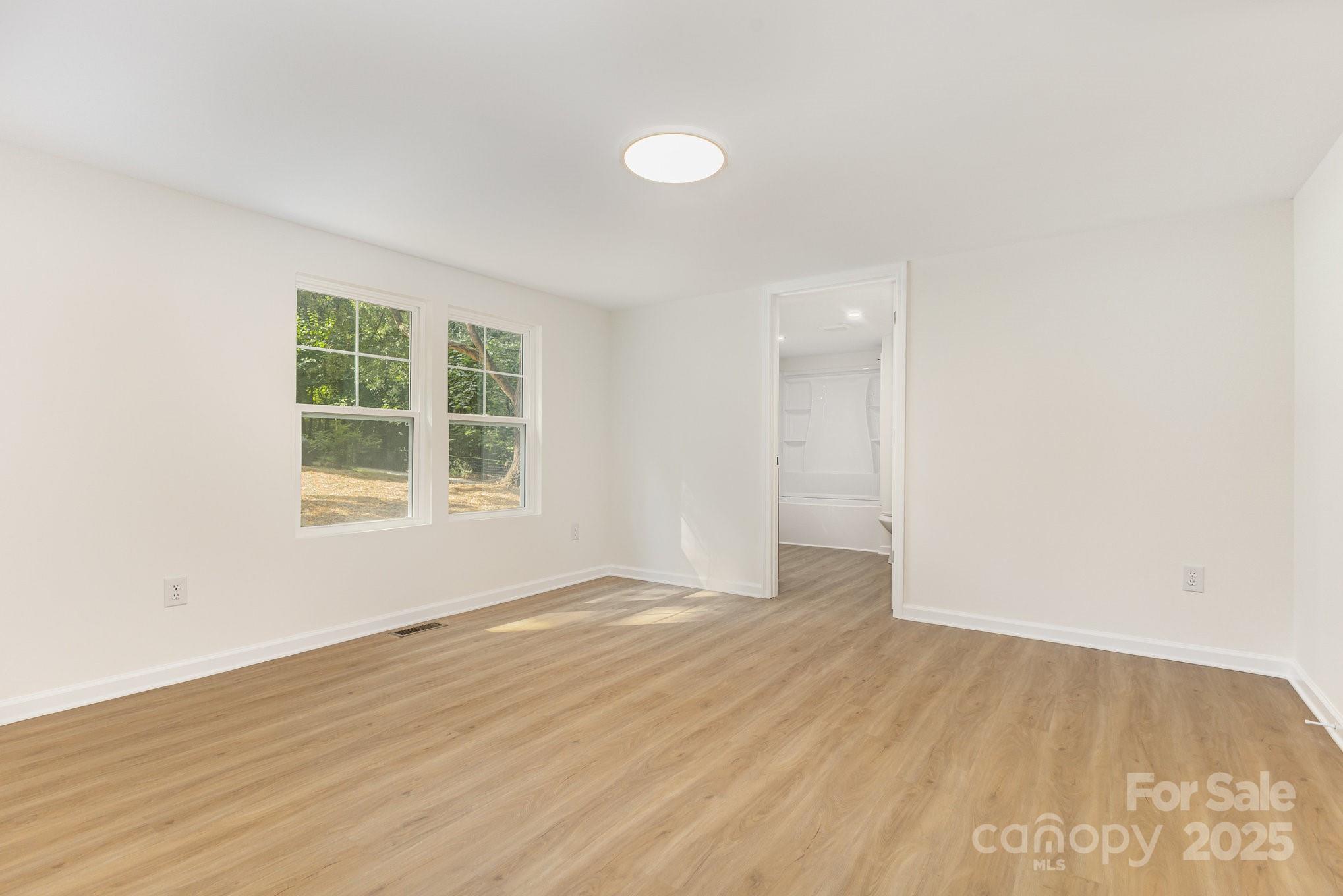 12180 A Coyle Road Stanfield, NC 28163 - Photo 8 of 16 an empty room with wooden floor and windows