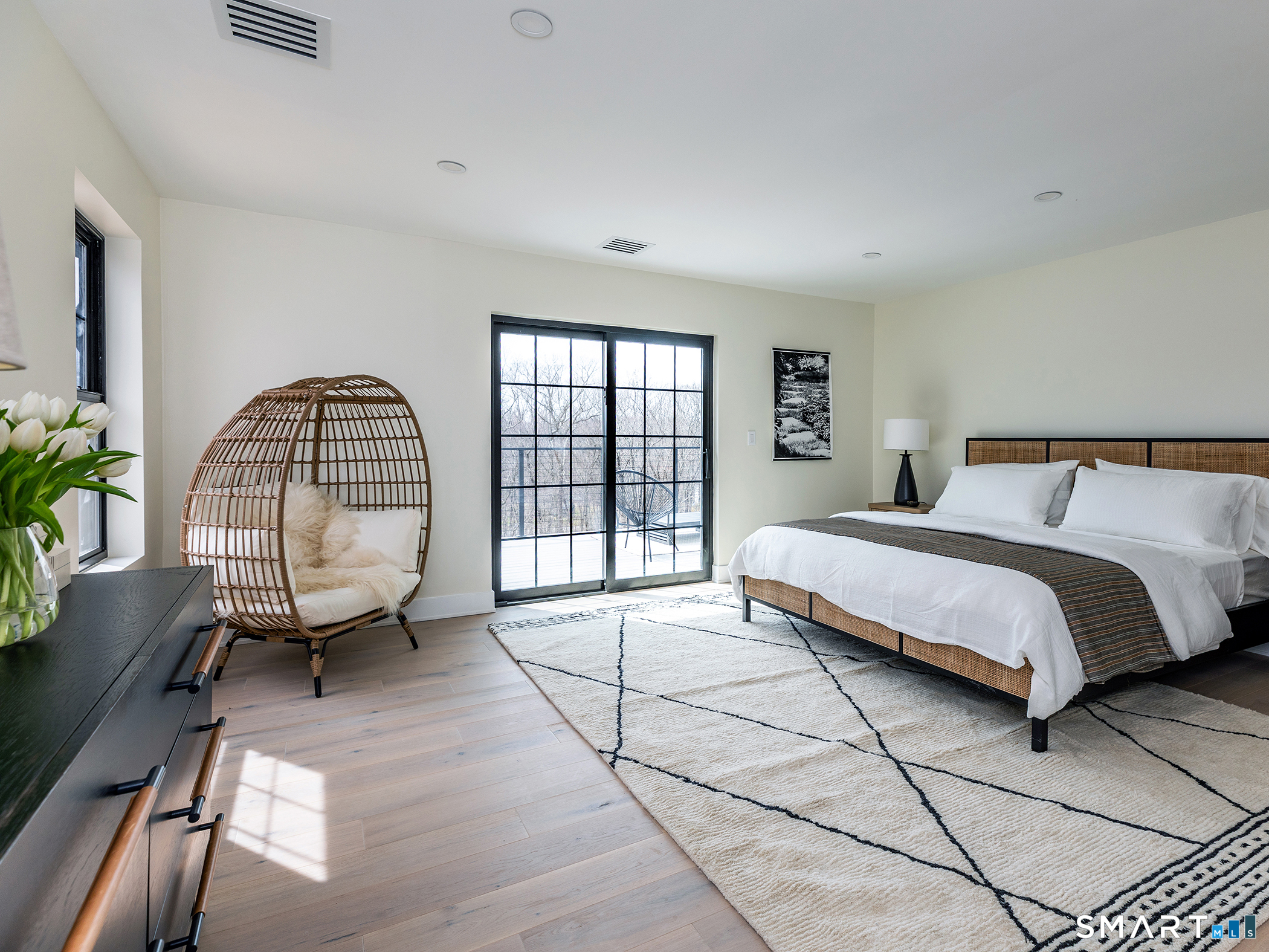 53 Mountain Lake Road Warren, CT 06777 - Photo 19 of 40 a spacious bedroom with a bed a table and potted plant