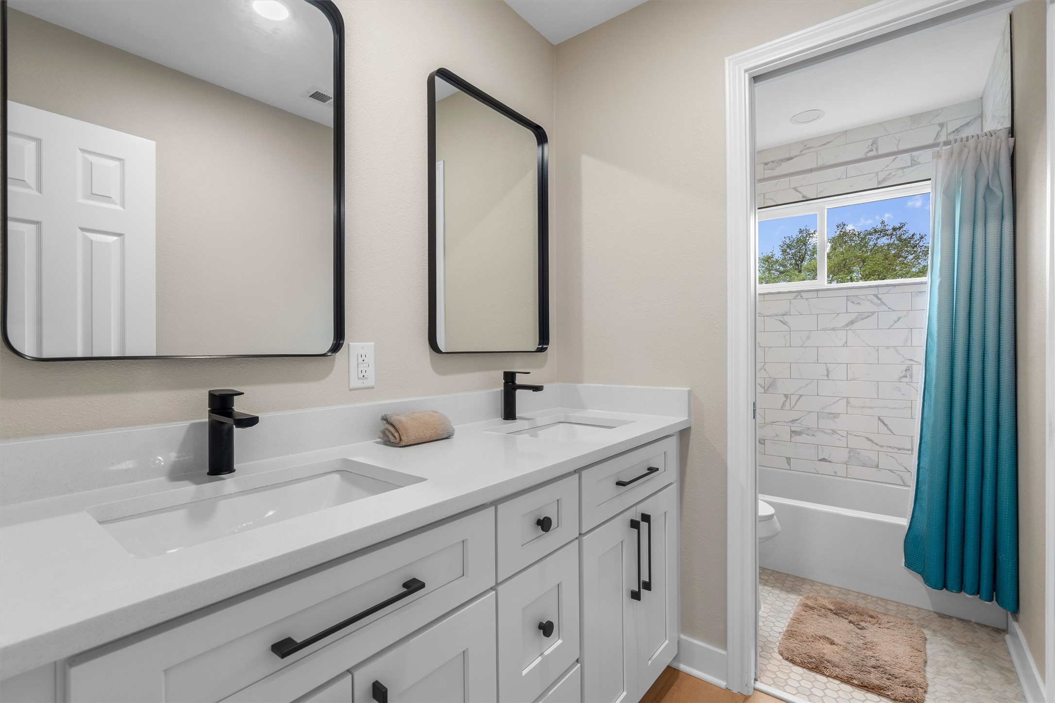 307 Hurst Creek Road Austin, TX 78734 - Photo 35 of 40 Dual vanity with white shaker-style cabinetry, matte black hardware, and integrated sinks
