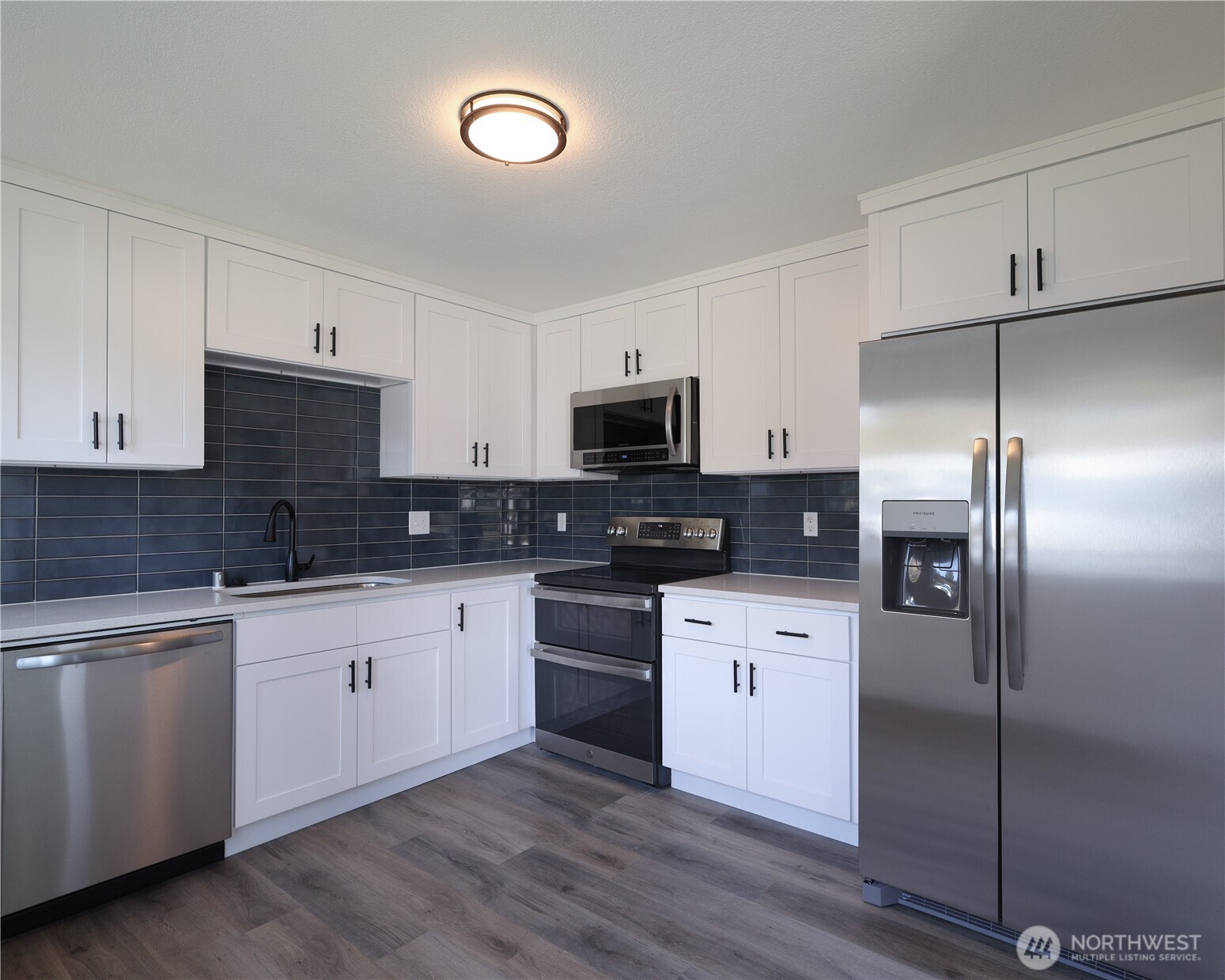 814 5th Street Steilacoom, WA 98388 - Photo 5 of 18 a kitchen with stainless steel appliances cabinets a sink and a stove