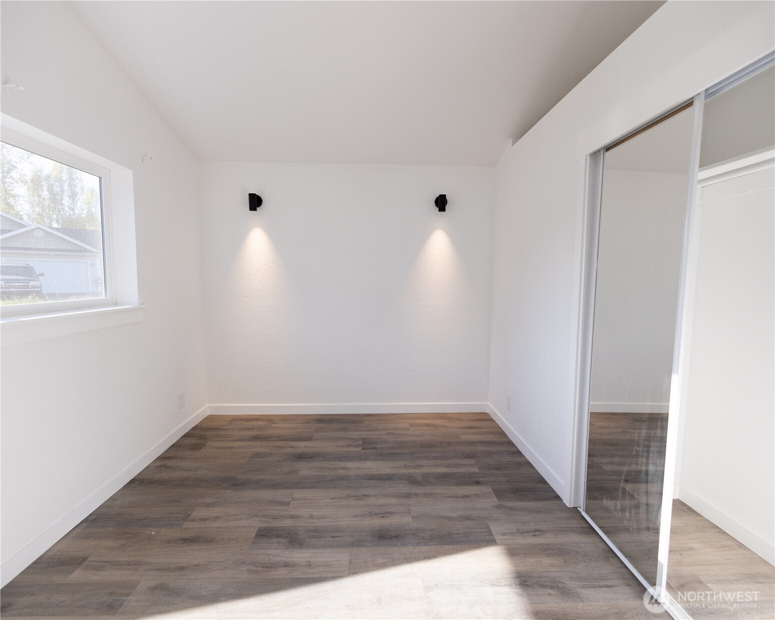 814 5th Street Steilacoom, WA 98388 - Photo 10 of 18 a view of an empty room with wooden floor and a window