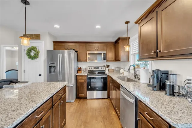 a kitchen with stainless steel appliances granite countertop a sink refrigerator and microwave