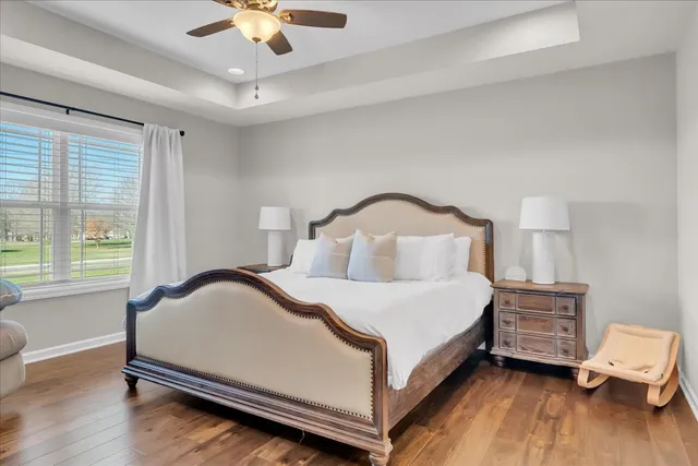 a bedroom with a bed a chandelier and a window