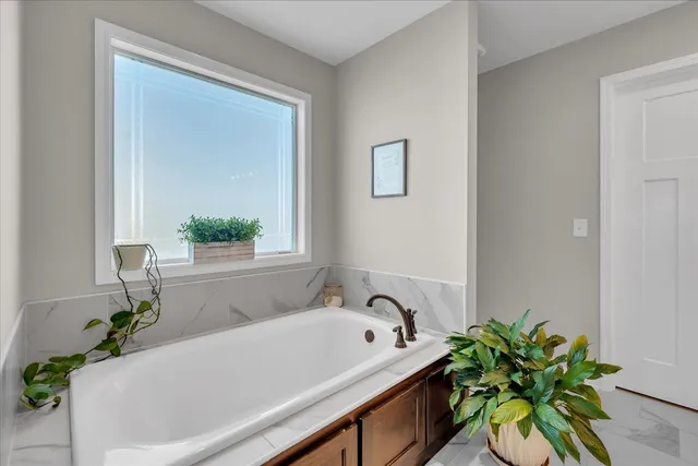 a bath tub sitting in a bathroom next to a window