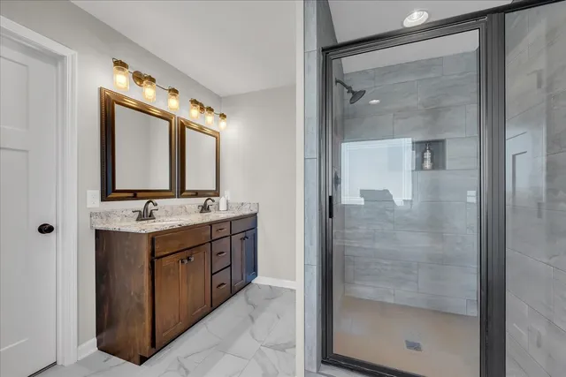 a bathroom with a granite countertop sink mirror and shower