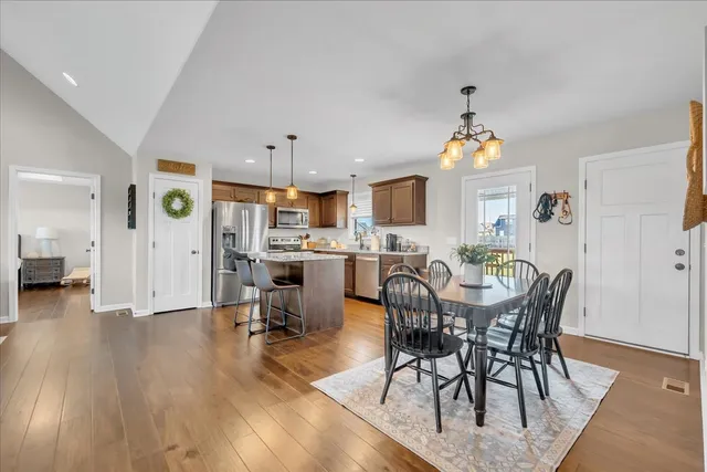 a view of a dining room and livingroom with furniture wooden floor a chandelier