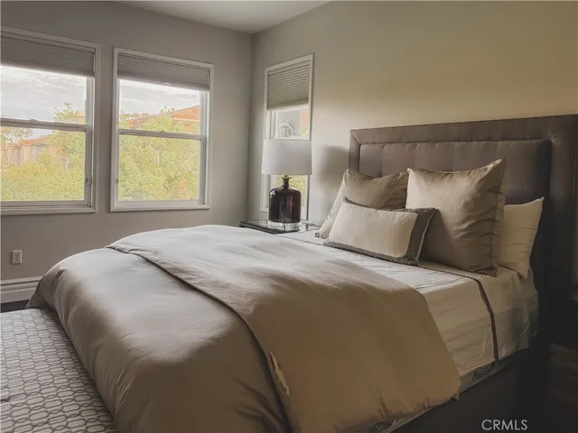 a large bed sitting in a bedroom next to a window