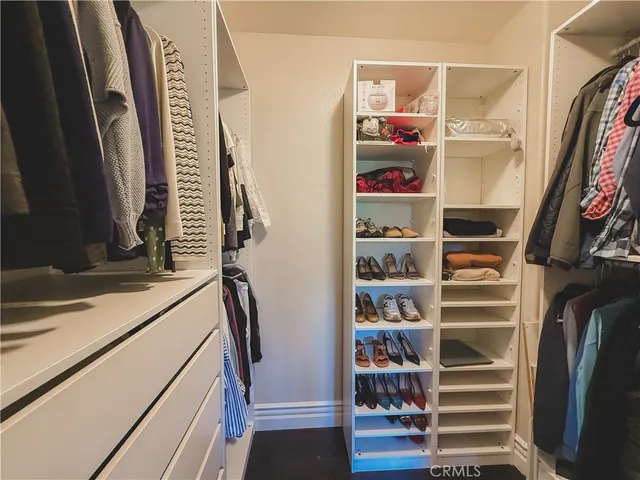 a view of walk in closet with clothes and shoes